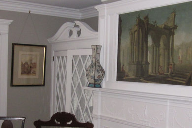 This is an example of a traditional family room in New York with grey walls, a standard fireplace and a plaster fireplace surround.