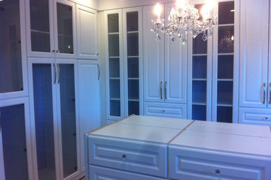 Walk-in closet - large traditional women's walk-in closet idea in New York with raised-panel cabinets and white cabinets