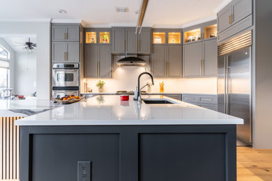 Eat-in kitchen - large transitional l-shaped eat-in kitchen idea in Houston with shaker cabinets, gray cabinets, quartz countertops, two islands and white countertops