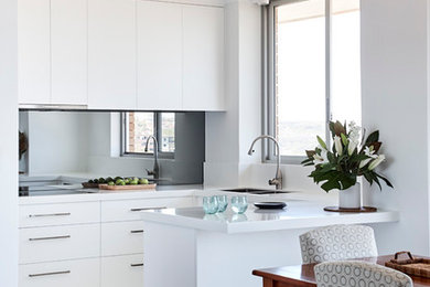 Mid-sized contemporary u-shaped kitchen in Sydney with an undermount sink, flat-panel cabinets, white cabinets, mirror splashback, stainless steel appliances, porcelain floors and white floor.