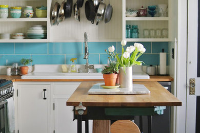 Inspiration for a country l-shaped dark wood floor enclosed kitchen remodel in Columbus with a drop-in sink, open cabinets, white cabinets, wood countertops, blue backsplash, subway tile backsplash, stainless steel appliances and an island