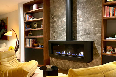 Imagen de salón abierto moderno de tamaño medio sin televisor con paredes multicolor, chimeneas suspendidas, marco de chimenea de piedra y suelo marrón