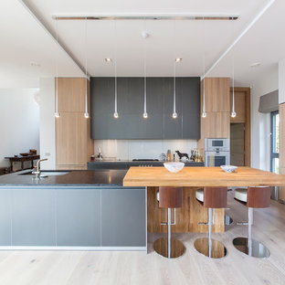 Design ideas for an expansive contemporary open plan kitchen in Surrey with light hardwood floors, with island and an undermount sink.