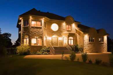 Large trendy beige three-story brick gable roof photo in New York