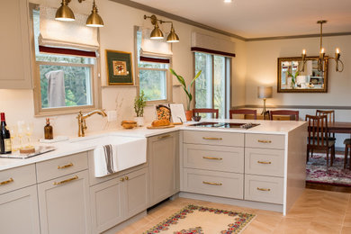 Inspiration for a mid-sized timeless l-shaped beige floor open concept kitchen remodel in Philadelphia with an undermount sink, shaker cabinets, beige cabinets, quartz countertops, white backsplash, stainless steel appliances and white countertops