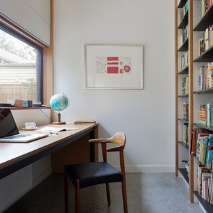 Inspiration for a contemporary study room in Melbourne with white walls, concrete floors and a built-in desk.