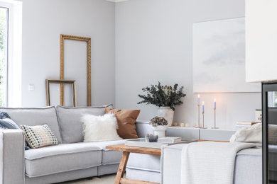 Mittelgroßes, Offenes Modernes Wohnzimmer mit grauer Wandfarbe, verputzter Kaminumrandung und TV-Wand in Stuttgart