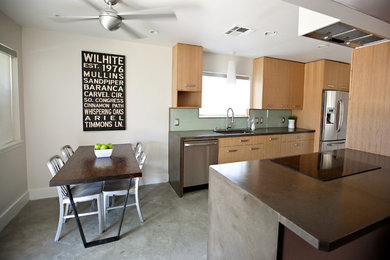 Eclectic eat-in kitchen photo in Houston with flat-panel cabinets, light wood cabinets, green backsplash and stainless steel appliances