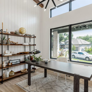 Inredning av ett modernt mellanstort hemmabibliotek, med vita väggar, klinkergolv i porslin, ett fristående skrivbord och brunt golv