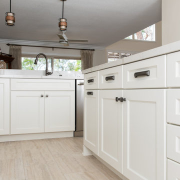Kitchen remodel with white cabinetry on perimeter and island