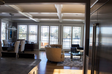 This is an example of a large traditional open plan living room in Boston with light hardwood flooring.