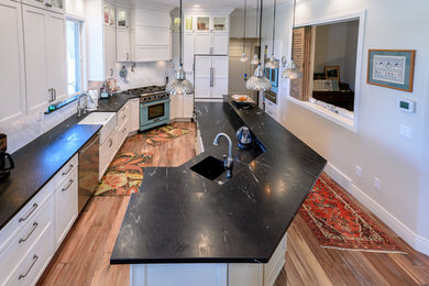 Kitchen pantry - mid-sized transitional medium tone wood floor and brown floor kitchen pantry idea in Denver with a farmhouse sink, shaker cabinets, white cabinets, soapstone countertops, white backsplash, ceramic backsplash, colored appliances and an island
