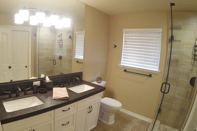 Example of a mid-sized transitional 3/4 beige tile, multicolored tile, white tile and ceramic tile ceramic tile and beige floor corner shower design in Other with recessed-panel cabinets, white cabinets, a two-piece toilet, beige walls, an undermount sink and a hinged shower door