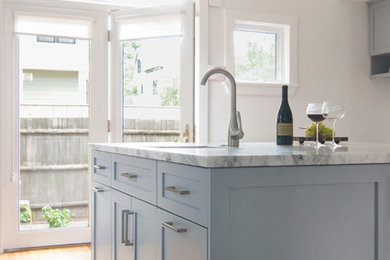 Enclosed kitchen - large contemporary l-shaped medium tone wood floor and brown floor enclosed kitchen idea in Boston with blue cabinets, quartzite countertops, multicolored backsplash, glass tile backsplash, paneled appliances, an island, a farmhouse sink and shaker cabinets