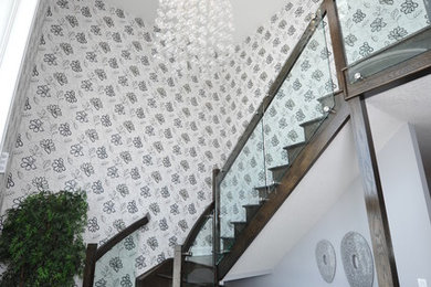 Example of a mid-sized minimalist wooden curved glass railing staircase design in Toronto with wooden risers