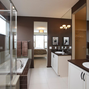 Foto di una stanza da bagno moderna con lavabo da incasso, ante con riquadro incassato, ante bianche, vasca da incasso, doccia ad angolo, piastrelle marroni e pareti marroni