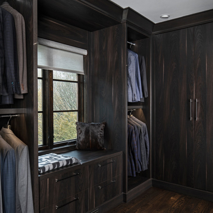 This walk-in closet, custom made with taupe flat slab cabinetry, is located off the master bath, creating a special sanctuary for the Him. Strong dark wood tones, sleek and modern, each and every cabi