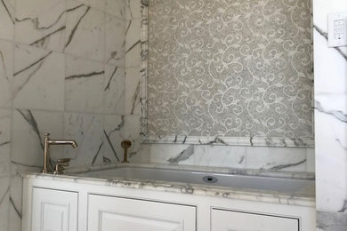Bathroom - transitional bathroom idea in Milwaukee with recessed-panel cabinets, white cabinets and marble countertops