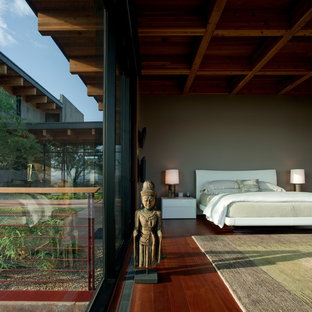 Esempio di una camera matrimoniale etnica con pareti marroni, parquet scuro, nessun camino e pavimento marrone