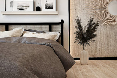 This is an example of a medium sized scandi guest and cream and black bedroom in West Midlands with white walls, laminate floors, beige floors, panelled walls and a feature wall.