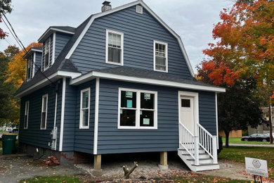 Modelo de fachada de casa azul y negra tradicional de tamaño medio de dos plantas con revestimiento de vinilo, tejado a doble faldón, tejado de teja de madera y tablilla