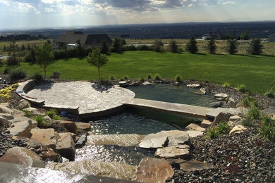 Inspiration for a large backyard brick patio fountain remodel in Other with no cover