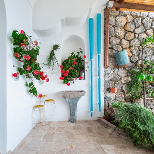 Foto di un patio o portico mediterraneo di medie dimensioni e davanti casa con pavimentazioni in pietra naturale e una pergola