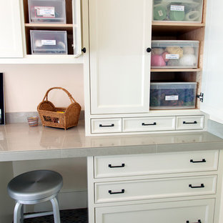 Photo of a mid-sized traditional craft room in Portland with white walls, a built-in desk and brown floor.