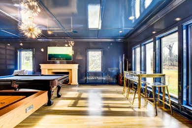 Diseño de sala de juegos en casa contemporánea con paredes azules, suelo de madera clara, todas las chimeneas y suelo beige