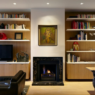 Design ideas for a medium sized modern study in London with light hardwood flooring, a standard fireplace, a stone fireplace surround and a freestanding desk.