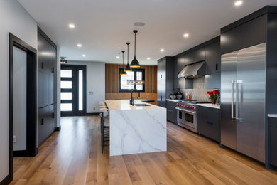 Mid-sized minimalist light wood floor kitchen photo in Cleveland with an undermount sink, flat-panel cabinets, gray cabinets, quartz countertops, gray backsplash, ceramic backsplash, stainless steel appliances and white countertops