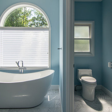 Traditional master bath utilizing frosted and clear glass to allow for needed pr