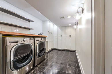 Utility room - mid-sized contemporary marble floor and black floor utility room idea in Cincinnati with an utility sink, shaker cabinets, white cabinets, wood countertops, white walls, a side-by-side washer/dryer and brown countertops