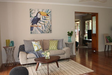 Ejemplo de salón para visitas abierto de tamaño medio con suelo de madera en tonos medios y paredes beige