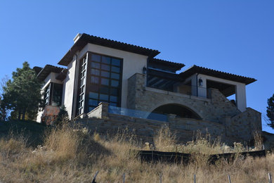 Large mediterranean beige two-story stucco house exterior idea in Denver with a hip roof and a tile roof