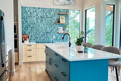 Inspiration for a mid-sized coastal l-shaped light wood floor, beige floor and vaulted ceiling open concept kitchen remodel in Other with an undermount sink, flat-panel cabinets, light wood cabinets, quartz countertops, green backsplash, glass tile backsplash, stainless steel appliances, an island and white countertops