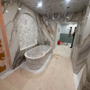 Sculptural Calacatta Gold Marble Bathroom with Hand-Carved Bathtub