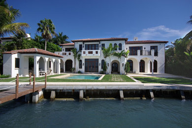 Huge traditional white two-story stucco exterior home idea in Miami