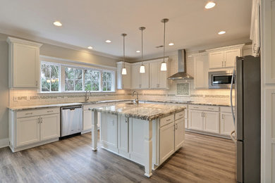 Large elegant u-shaped medium tone wood floor eat-in kitchen photo in Atlanta with an undermount sink, granite countertops, white backsplash, ceramic backsplash, stainless steel appliances, an island, recessed-panel cabinets and white cabinets