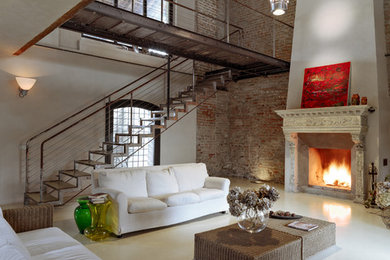 Ispirazione per un soggiorno moderno con pavimento in cemento e camino classico