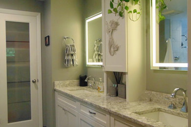 Design ideas for a mid-sized beach style master bathroom in Bridgeport with shaker cabinets, white cabinets, beige tile, green walls, vinyl floors, an undermount sink and granite benchtops.
