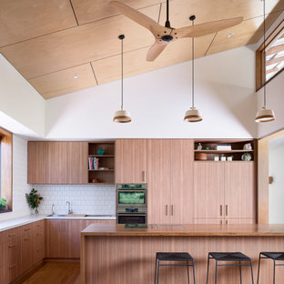 Mid-sized contemporary l-shaped open plan kitchen in Brisbane with a double-bowl sink, open cabinets, medium wood cabinets, concrete benchtops, white splashback, ceramic splashback, stainless steel appliances, light hardwood floors, with island, grey benchtop and timber.