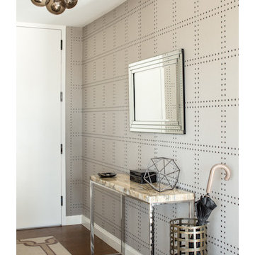 Decorative objects and a granite table balance the neutral elements of the foyer