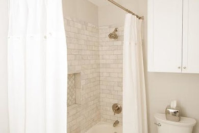 Inspiration for a small transitional gray tile, white tile and subway tile mosaic tile floor bathroom remodel in Other with recessed-panel cabinets, white cabinets, a two-piece toilet, white walls and an undermount sink
