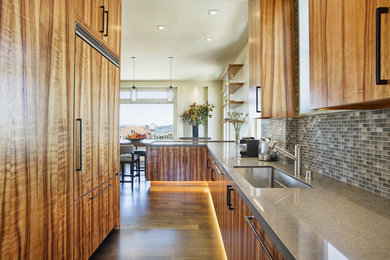 Kitchen - contemporary galley medium tone wood floor kitchen idea in San Francisco with an undermount sink, flat-panel cabinets, medium tone wood cabinets, multicolored backsplash, mosaic tile backsplash, paneled appliances and a peninsula
