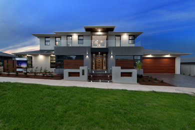Large modern two-storey grey house exterior in Canberra - Queanbeyan with a flat roof and a metal roof.