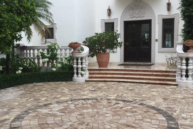 Inspiration for a large mediterranean front yard full sun driveway in Miami with concrete pavers.