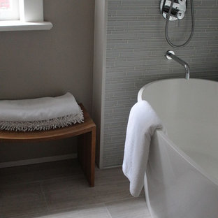 Foto di una piccola stanza da bagno per bambini moderna con ante lisce, ante bianche, vasca freestanding, vasca/doccia, WC monopezzo, piastrelle bianche, piastrelle di vetro, pareti grigie, pavimento in marmo, lavabo sottopiano e top in quarzo composito