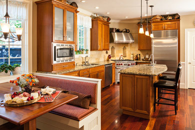 Inspiration for a mid-sized timeless l-shaped dark wood floor eat-in kitchen remodel in Boston with a double-bowl sink, recessed-panel cabinets, dark wood cabinets, granite countertops, beige backsplash, stone tile backsplash, stainless steel appliances and an island