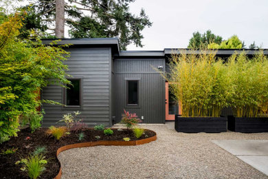 Mid-century modern black one-story flat roof idea in Portland